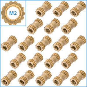 May include: Twenty brass threaded inserts, each with a serrated outer edge and a smooth inner edge. The inserts are arranged in a grid pattern on a white background. The text "M2" is visible in the upper left corner of the image.