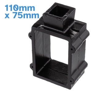 Peut inclure: Boîte carrée en fonte noire avec une ouverture de 110 mm de diamètre et des côtés de 75 mm. La boîte a un rebord surélevé autour de l'ouverture.