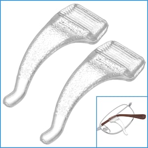 Könnte beinhalten: Zwei transparente Kunststoff-Nasenpads für Brillen. Die Pads sind so konzipiert, dass sie verhindern, dass die Brille von der Nase rutscht. Die Pads sind auf weißem Hintergrund abgebildet.