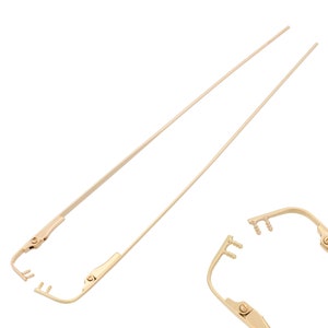 May include: A pair of gold-tone metal eyeglass arms with a hinge and screw detail. The arms are separated and laid out on a white background.