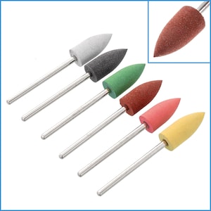 May include: Set of seven sanding bands with different coloured abrasive tips attached to metal shafts. The tips are pointed and come in white, grey, green, brown, pink, and yellow.