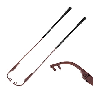 May include: A pair of brown metal eyeglass arms with black rubber tips. The arms are designed to be attached to eyeglasses.