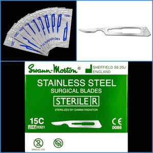 May include: A pack of 15C sterile surgical blades in a green box with the brand name Swann-Morton. The box says "Stainless Steel Surgical Blades" and "Sterile R". The blades are individually packaged and labeled with "15C".