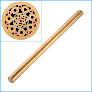 May include: A close-up of a brass rod with a cross-section revealing a circular pattern of concentric rings in shades of gold, silver, and copper.