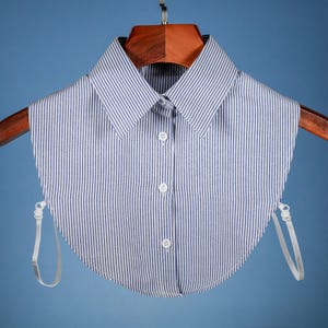 Puede incluir: Un cuello falso a rayas blancas y azules con cierre de botón y correas ajustables. El cuello está hecho de una tela ligera y está diseñado para usarse con una variedad de blusas.