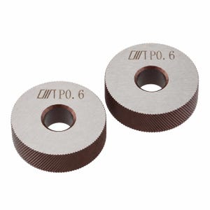 May include: Two circular metal knurling wheels with a central hole. Each wheel features a silver-toned flat face with the engraved text "T P0. 6" and a dark brown, textured, diagonal-patterned outer edge for grip during mechanical operations.