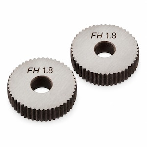 May include: Two circular metal gears with serrated edges and a central hole. Each gear features a brushed silver finish on the top surface with the text FH 1.8 clearly engraved in black. The sides of the gears are dark grey with vertical teeth.
