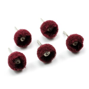 May include: Five red sanding brushes with metal shafts. The brushes are round and have a fuzzy texture.