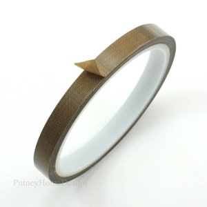 May include: A roll of brown heat-resistant tape with a textured surface. The tape is rolled up and a small portion is peeled back to show the adhesive side.