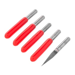 May include: Five red and silver router bits with a pointed tip. The bits are arranged in a row, with the tips pointing to the right.