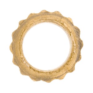 May include: A gold-colored metal ring with a scalloped edge. The ring is slightly worn and has a rustic appearance.