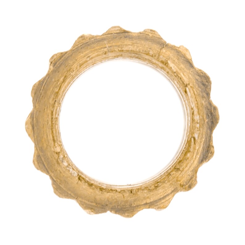 May include: A gold-colored metal ring with a scalloped edge. The ring is slightly worn and has a rustic appearance.