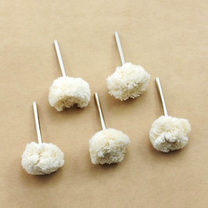 May include: Five white buffing wheels with metal shafts. The buffing wheels are attached to the shafts with a silver metal band.