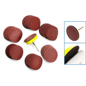 May include: A set of 12 brown sanding discs with a yellow sanding pad and a metal spindle. The sanding discs are round and have a rough texture. The sanding pad is attached to the spindle with a screw.