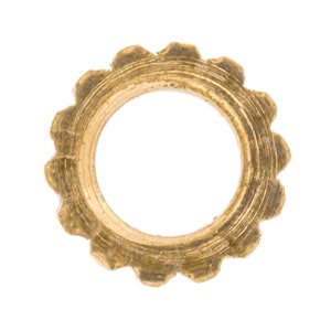 May include: A gold-colored metal washer with a serrated edge. The washer has a circular shape with a hole in the center.