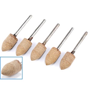 Könnte beinhalten: Satz mit sechs braunen Schleifkegeln mit Metallstielen. Die Kegel sind spitz und haben eine raue Textur.