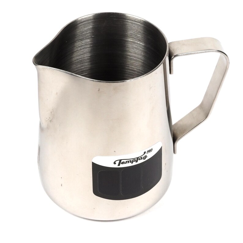 May include: A stainless steel milk frothing pitcher with a TempTag Pro label. The pitcher has a rounded bottom and a handle.