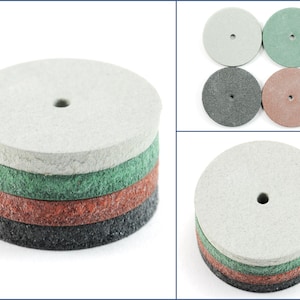 Puede incluir: Conjunto de cuatro discos de lija de diferentes granos. Los discos están apilados uno encima del otro, con el grano más grueso en la parte inferior y el grano más fino en la parte superior. Los discos son todos redondos y tienen un agujero en el centro para montarlos en una herramienta de lijado.
