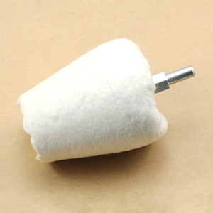 May include: A white cone-shaped buffing wheel with a metal shank. The buffing wheel is used for polishing and smoothing surfaces.