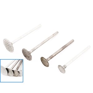May include: Set of four silver diamond-tipped grinding bits with a round shape. The bits are attached to silver metal shafts.