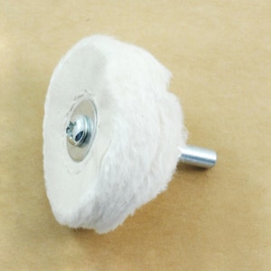 May include: A white cotton buffing wheel with a metal shank and a screw-on metal centre. The buffing wheel is used for polishing metal.