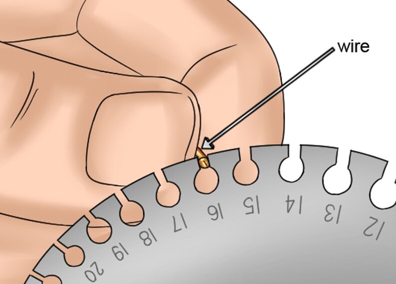 Puede incluir: Una herramienta de calibre de alambre de metal con agujeros numerados para medir el grosor del alambre. Un alambre se est&aacute; insertando en el agujero etiquetado como "16".