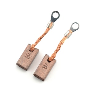 May include: Two brown carbon motor brushes with copper wire leads and metal loops. The brushes have the letter "W" stamped on them.