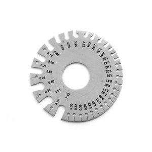 Puede incluir: Una galga de metal plateado con un agujero circular en el centro y una serie de marcas alrededor del borde. Las marcas incluyen n&uacute;meros y fracciones de pulgada, como 0,19, 0,21, 0,23, 0,25, 0,27, 0,30, 0,32, 0,35, 0,38, 0,42, 0,46, 0,51, 0,56, 0,61, 0,71, 0,81, 0,91, 1,02, 1,22, 1,42, 1,63, 1,83, 2,03, 2,34, 2,64, 2,95, 3,25, 3,66, 4,06, 4,47, 4,88, 5,39, 5,89, 6,40, 7,01 y 7,62.