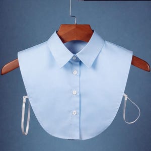 Camisa feminina clássica azul-clara com gola falsa em algodão, modelo Oxford, com botões e estilo clássico.