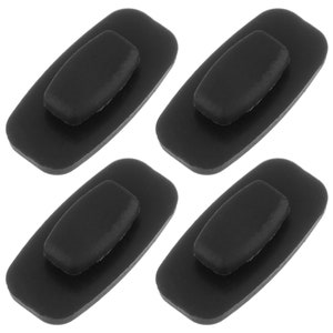 Może przedstawiać: Cztery czarne gumowe klawisze do klawiatury mechanicznej. Każdy klawisz ma wypukły, prostokątny kształt w środku.