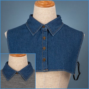 Op de afbeelding: Een denim kraag met een knoopsluiting. De kraag is lichtblauw en heeft een bruine knoop. De kraag zit op een wit mannequin.