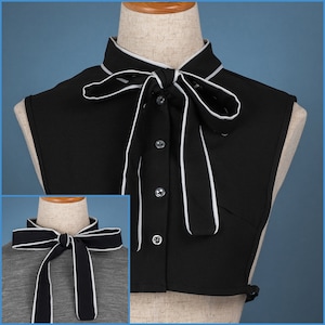 Può includere: Un colletto finto nero con bordino bianco e un papillon bianco. Il colletto è realizzato in un tessuto morbido e leggero ed è perfetto per aggiungere un tocco di stile a qualsiasi outfit.