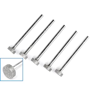 May include: Five silver metal diamond tipped grinding bits with a rounded head. The bits are used for grinding and polishing.
