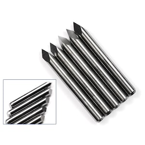 May include: A set of six silver-coloured, pointed, metal tools with a diamond-shaped tip. The tools are arranged in a fan shape, with the tips pointing towards the centre.