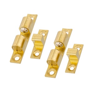 May include: Two sets of brass cabinet door catches with a ball bearing. Each set includes a catch and a strike plate.