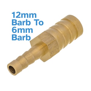 Può includere: Raccordo per tubo flessibile in ottone, con riduzione da 12 mm a 6 mm. Il raccordo presenta una sezione centrale esagonale ed estremità scanalate per un fissaggio sicuro del tubo. Il testo "12mm Barb To 6mm Barb" è in blu.