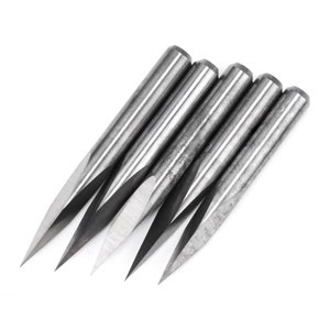 May include: Five silver-coloured, pointed wood carving tools with a sharp tip. The tools are arranged in a fan shape.