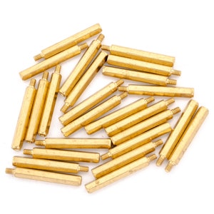 May include: A group of 20 brass standoffs, also known as spacers, in various lengths. The standoffs are hexagonal in shape and have a shiny, metallic finish.