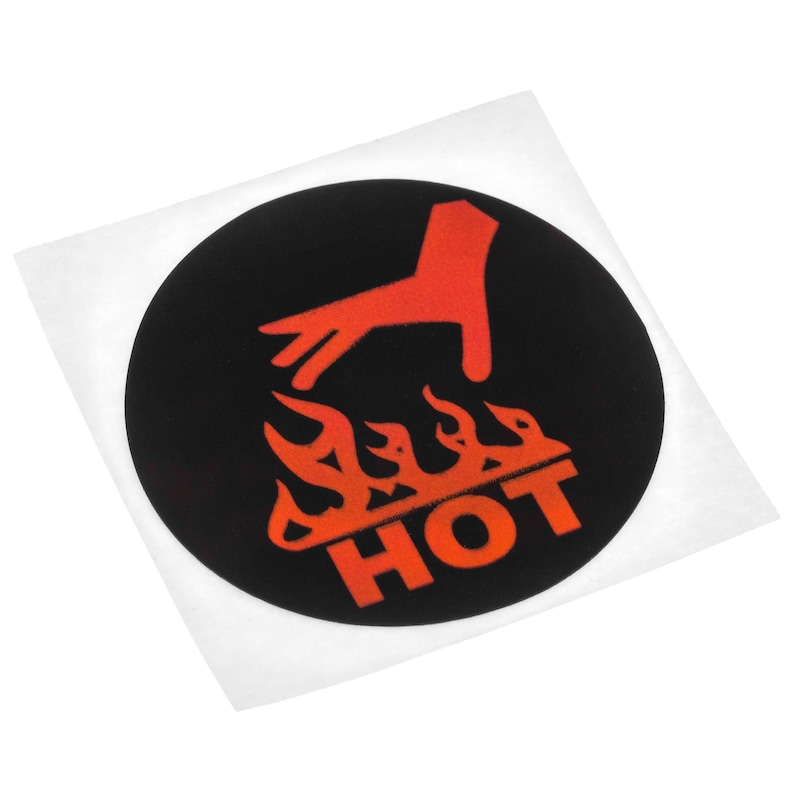 Op de afbeelding: Een ronde zwarte sticker met een rode afbeelding van een hand boven vlammen en het woord "HOT" in het rood. De sticker zit op een witte achtergrond.