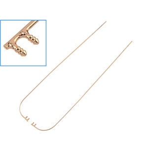 Peut inclure: Une clé en métal doré avec un design unique. La clé a un long manche fin et une tête décorative avec deux petits boutons ronds. La clé est pliée en forme de U.