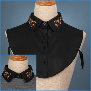 Puede incluir: Un cuello falso negro con un diseño de bordado floral. El cuello está hecho de una tela suave y ligera y tiene un estilo simple y elegante.