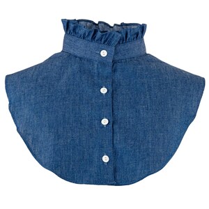 K&ouml;nnte beinhalten: Ein Denim-Kragen mit R&uuml;schenkante und vier wei&szlig;en Kn&ouml;pfen. Der Kragen ist hellblau.