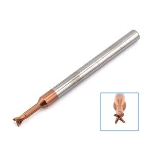 May include: A close-up of a silver and copper coloured end mill with four cutting edges. The end mill is a type of cutting tool used in machining.