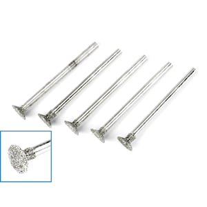 May include: A set of five silver-colored diamond burr bits with a cylindrical shaft and a flat, circular grinding head. The grinding heads are covered in small, sparkling diamond particles. A close-up inset shows a detailed view.