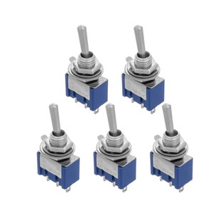 Op de afbeelding: Vijf zilveren schakelaars met blauwe kunststof bases. Elke schakelaar heeft een label met "ON" en "OFF" en "6A 125V AC".