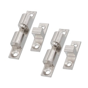 May include: Two sets of silver-toned, spring-loaded, self-closing cabinet door catches. Each set includes a catch and a strike plate.