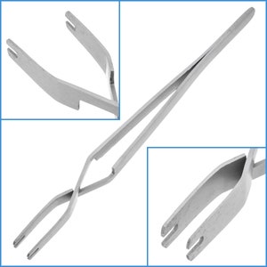May include: A pair of silver-toned tweezers with a unique crossed design. The tweezers have a pointed tip and are ideal for delicate tasks.