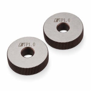 Puede incluir: Dos rodillos de roscado circulares de metal con un acabado gris oscuro y un orificio central. Los bordes exteriores presentan dientes verticales finos y serrados. Cada rodillo tiene grabado el texto TP1.0 en la superficie plana.