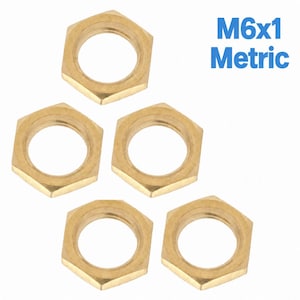 May include: Five gold-colored hexagonal metal nuts arranged in a pattern. Each nut features a circular threaded opening in the center. The text M6x1 Metric is printed in blue in the upper right corner, indicating the specific size and thread type.