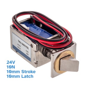 Può includere: Una serratura per porte elettrica argentata con una corsa di 10 mm e un chiavistello di 10 mm. La serratura è etichettata "TAU-S0837DL" e ha un filo rosso e nero collegato. La serratura è progettata per 24 V e 10 N.